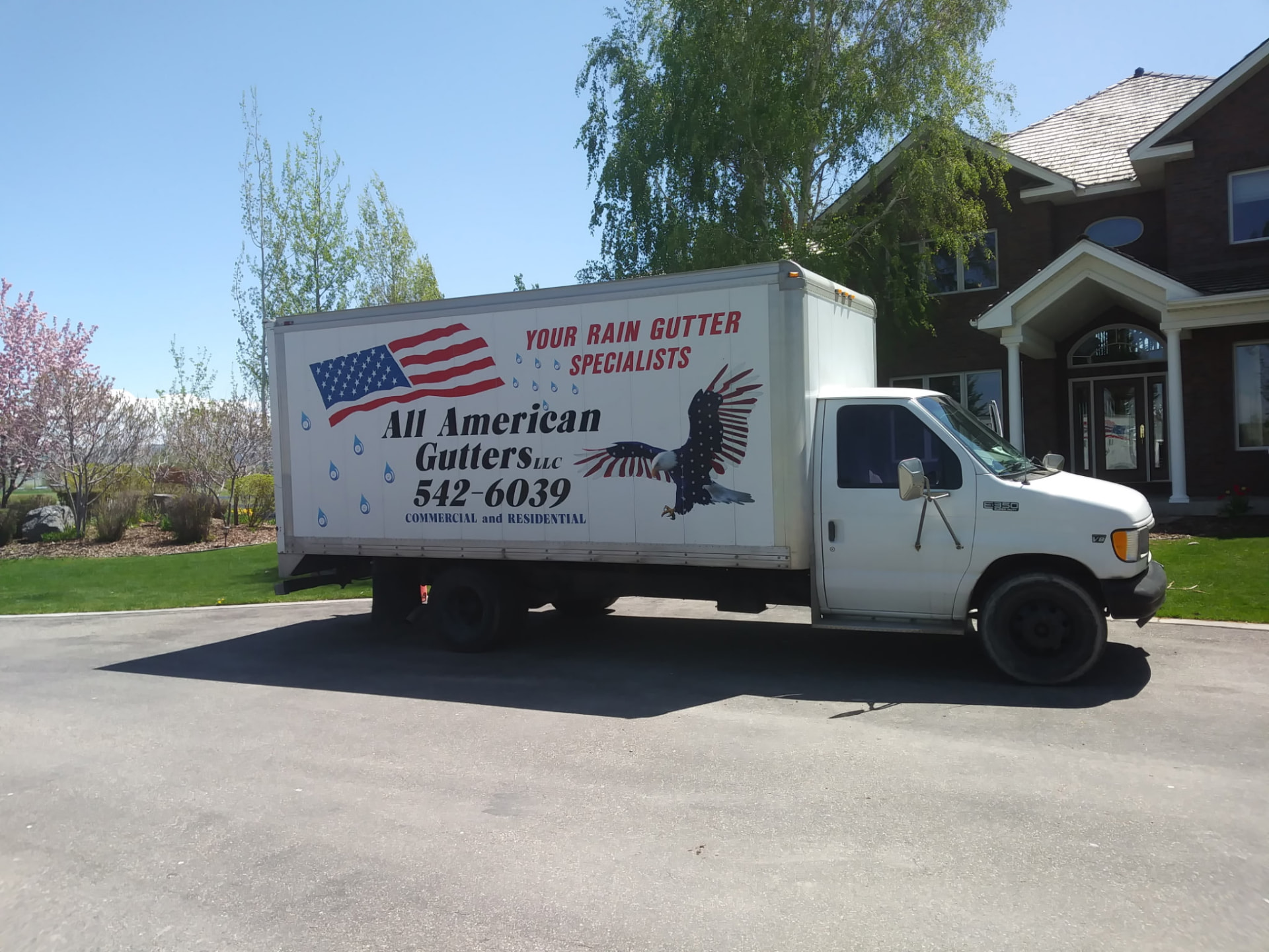 The All American Gutters truck parked in the driveway of an Eastern Idaho home before a gutter installation